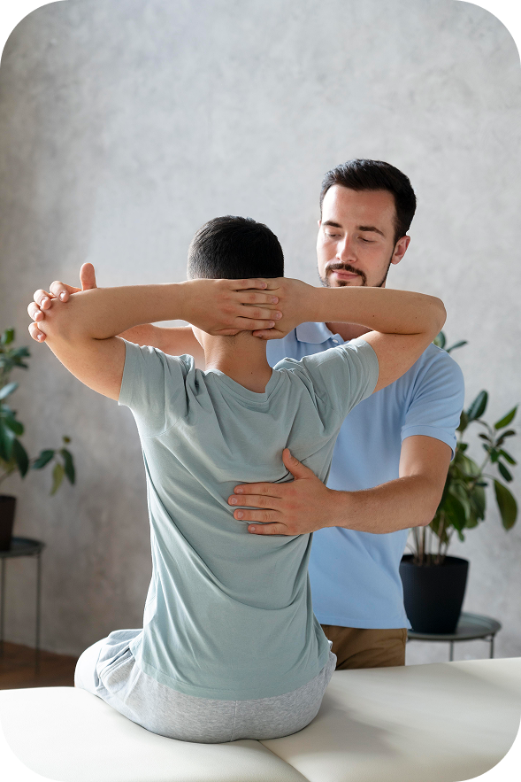 A male patient is getting a guided stretch from a physiotherapist who is helping him extend his arms and rotate his torso to improve flexibility.